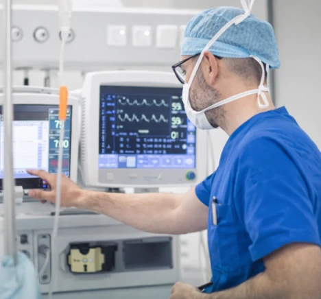 Anesthesia provider adjusting an anesthesia machine and patient monitor in the operating room