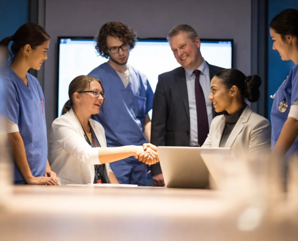 Practice leaders shaking hands with clinical staff at the end of a meeting